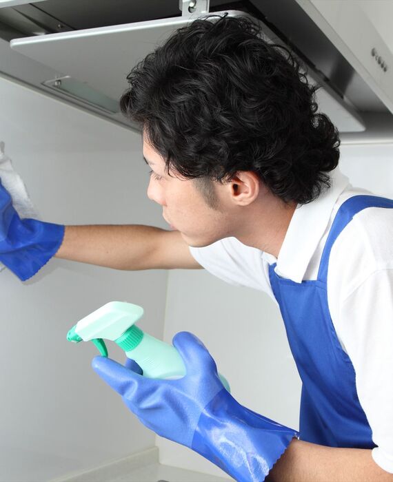 キッチンの壁掃除を行うスタッフ